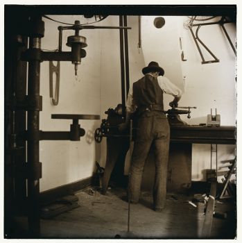 Wilbur_Wright_Working_in_the_Bicycle_Shop,This image is in the public domain.