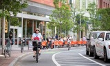 Older_woman_with_flowers_protected_bike_lane_boston