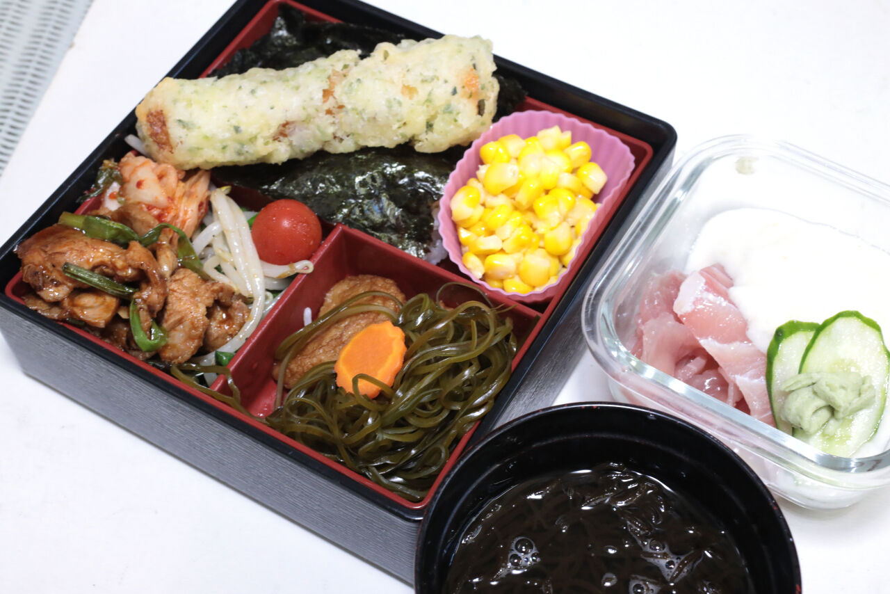 海苔弁 マグロ山かけ ちくわ磯辺揚げ 豚肩ロースのスタミナ焼き さつま揚げと切り昆布の煮付け 地場産トウモロコシのバターコーン もずく汁 今日の弁当 問題