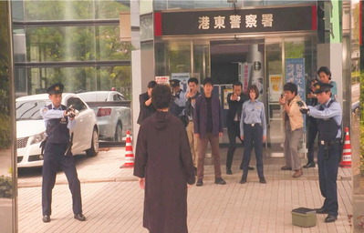 久遠に銃を向けている警察官たち