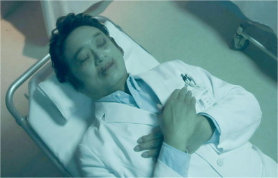 手をクロスして死んでいる国原の遺体