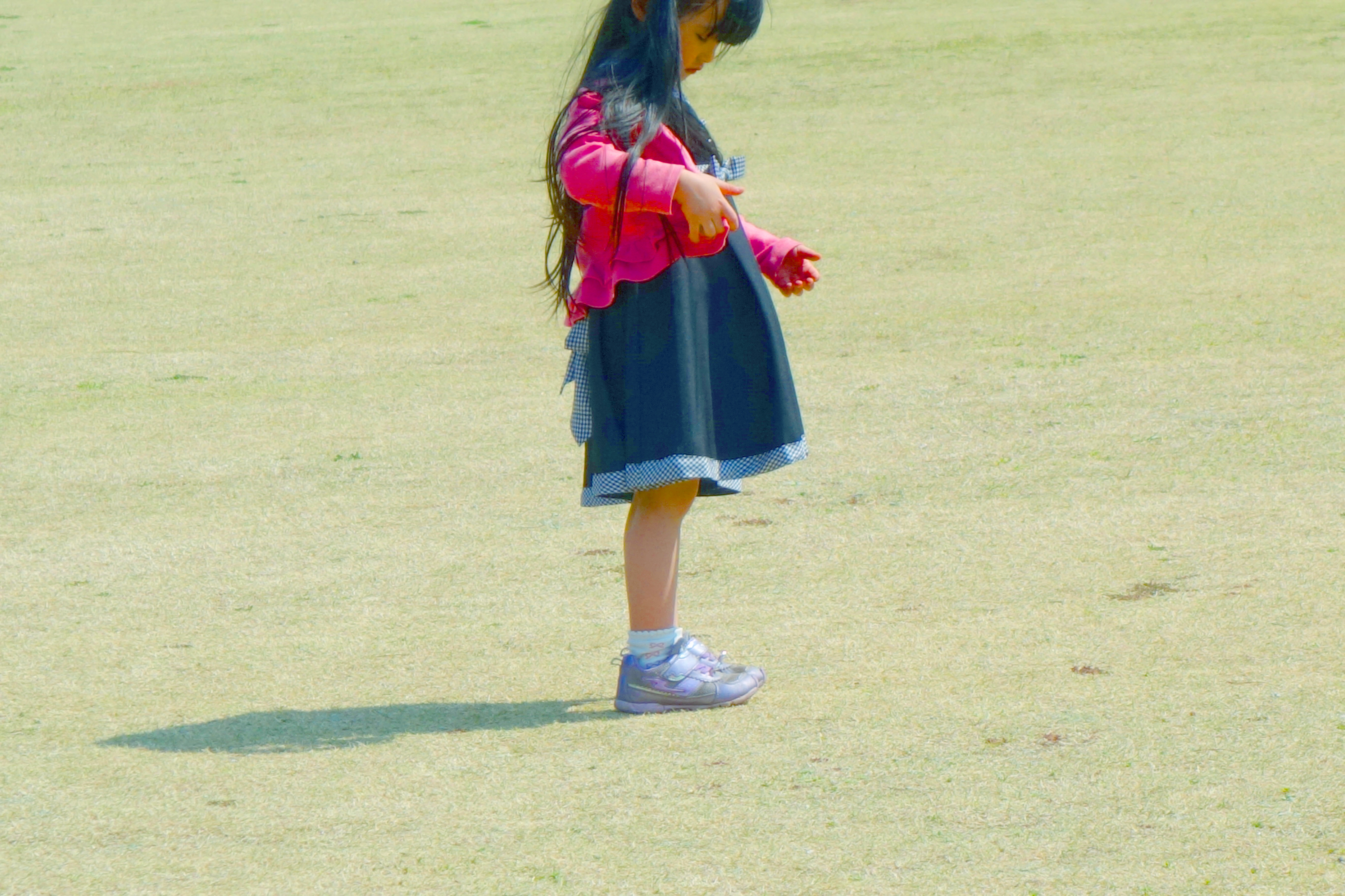 公園の芝生で遊ぶ少女 Freebackphoto