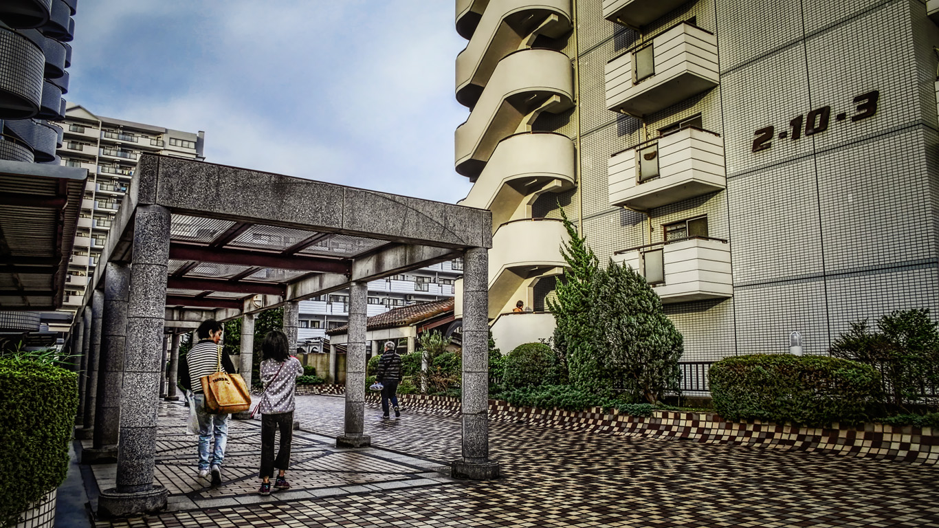 どこもかしこもタイル貼りで土の地面がないツルツルの団地に帰る人々という感じのｈｄｒ はやしのなか