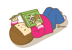 寝そべって本を読むこども