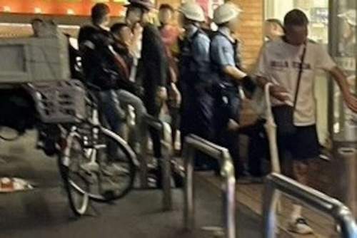 コンビニにたむろするクルド人と日本人の若者グループに注意する警察官ら＝昨年11月、埼玉県川口市