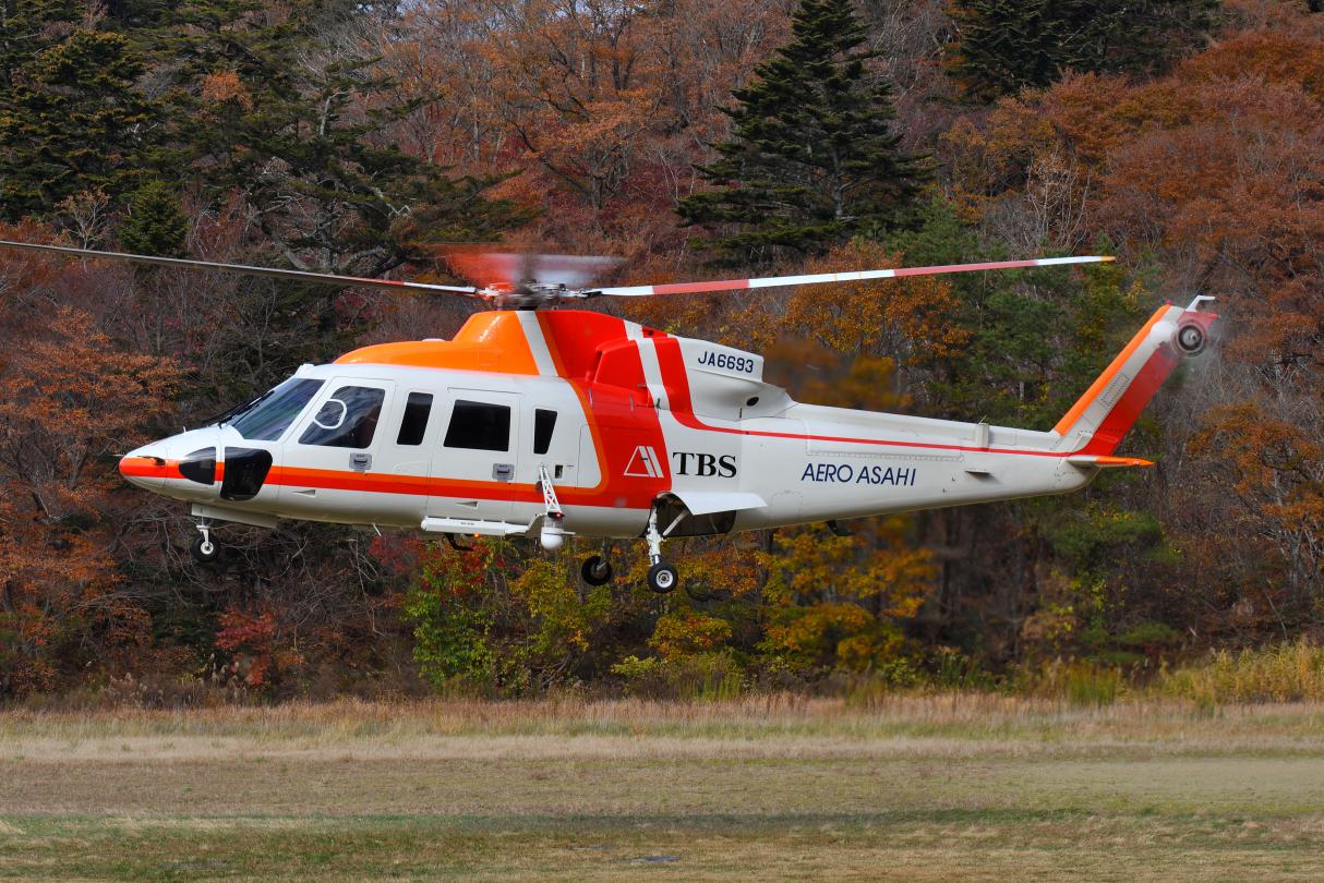紅葉を背景にヘリコプターを撮る ひこうき雲