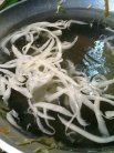 刀削された麺が茹でられます