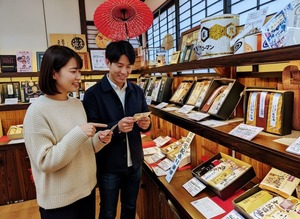 キッコーマン御用蔵しょう油の取扱い店で、お年賀を買うカップル