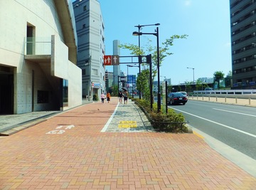 炎天下に人気も少ない都心の歩道