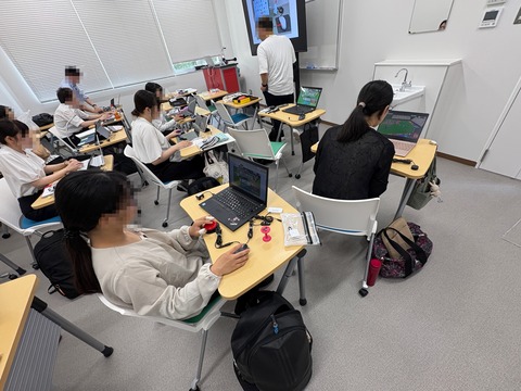 マウスに接続したアクセシビリティスイッチを試す院生