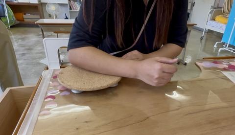 小学部時代の担任が作った前腕支持具の使い方を見せてくれる教員