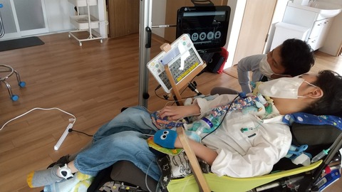足に装着した筋電センサーを試す中学生