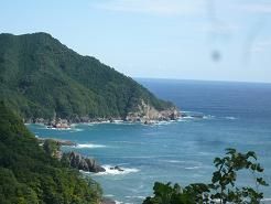山あいの道の 合間に岸壁と海