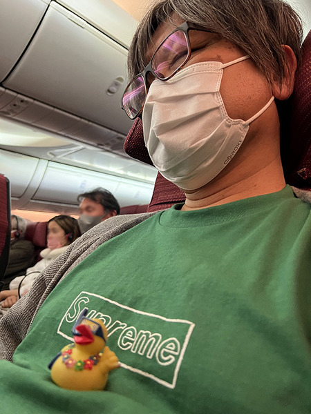飛行機で寝ている人