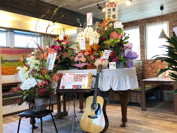 12グランドピアノに開店祝いのお花がたくさん