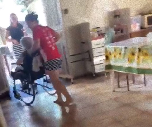 車椅子のおばあさんを気遣う犬の愛情