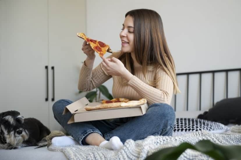 young-woman-eating-pizza-bed_e