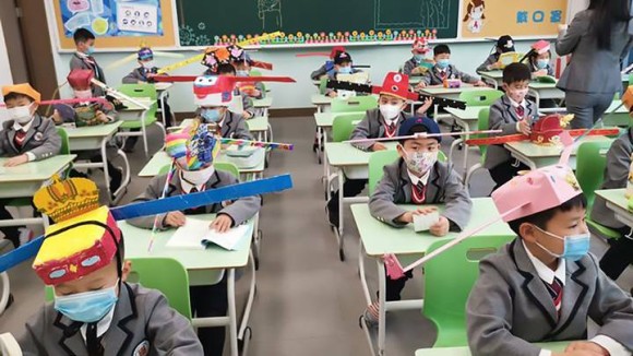 小学校が再開された中国では、宋時代の官僚を模した帽子でクリエイティブに社会的距離の実行（浙江省）