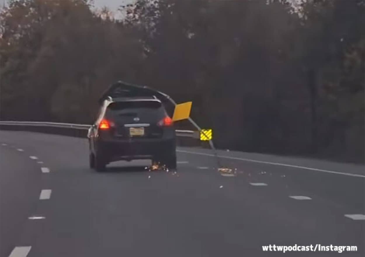 道路標識をひきずりながら走る車