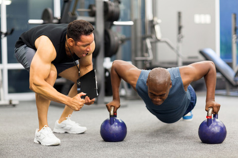 personal-trainer-motivates-client-doing-push-ups