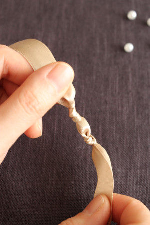 ビーズをおさえるようにさらに上を結んで留めます。 ※ビーズが落ちるのが心配なときは、透明ワイヤーにビーズを通しながら作業すると良いかも。