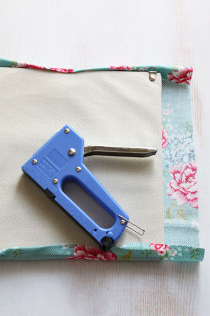 1.インテリアパネルのサイズより 縦横ともに5cm多くカットした布を タッカーを使いパネルに貼ります。