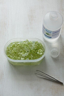 1．保存容器に第１加工液を８分目まで注ぎ、紫陽花を２輪浸します。 セロファンなどを溶液に密着するようにかぶせ、容器の蓋をして１日おきます。