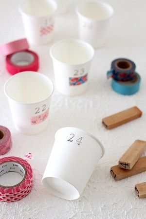 1.紙コップに1~24の数字を書いておきます。 今回は数字のスタンプを使用しました。 スタンプを押す場合には、紙コップを重ねると上手に押すことができます。 数字の下にマスキングテープを貼ると可愛さUPです♪