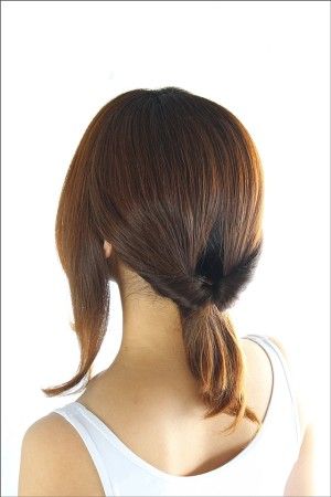 両サイドを残し、髪をゴムで後ろに束ねます。 結び目の上に隙間をあけ、 毛束を上からくぐらせ、ひねりを入れます。