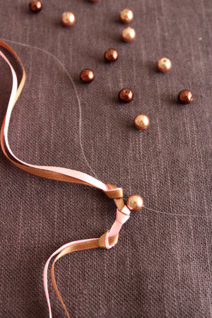 透明ワイヤーを最初の結び目に通しビーズを入れ、ワイヤーを次の結び目に通します。※ワイヤーの先は玉止めをしてはずれないようにしてください。