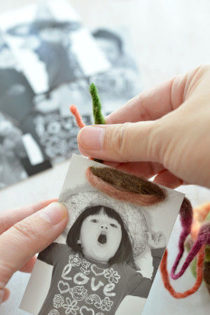 写真の穴に写真のようにひもを通していきます。写真→フラッグ→写真…という風に交互に通していきます。