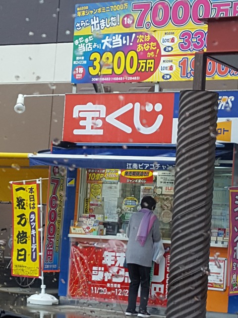 雨にも負けず、宝くじを買い求める市民 撮影・たかのぶ