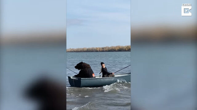 ヒグマと一緒に釣りを楽しむロシア人女性。ロシア、ノボシビルスク湖にて