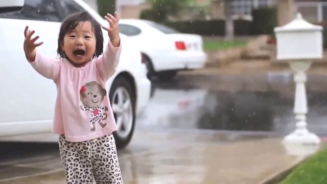 小さな女の子が初めての雨に興奮する様子が微笑ましく可愛らしい