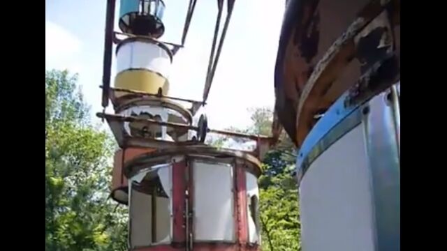廃墟の遊園地のボロボロになった観覧車が風に吹かれてゆっくり回る光景