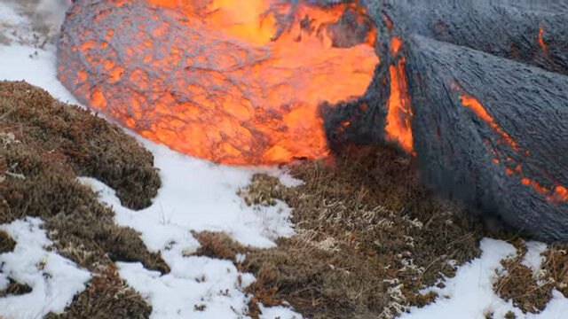 雪の上を溶岩が流れていく光景。アイスランドの火山噴火で撮影