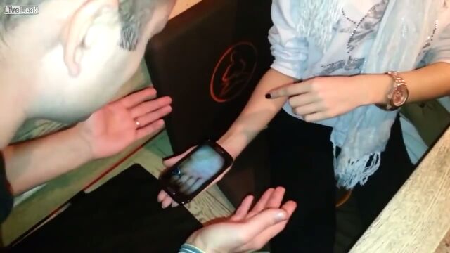 手のひらに乗せたスマホの中にゴキブリが!ちょっとゾクッとする手品を見せるロシアの店員さん