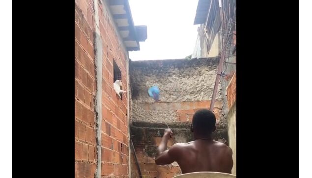 極狭な路地裏、わずかに見える空に向かって凧揚げする男。凧の性能も男の腕も凄すぎる