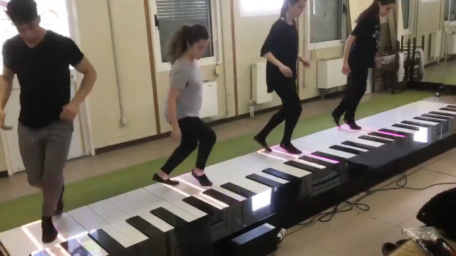 足で演奏する巨大ピアノを4人で連弾。チームワークが素晴らしい