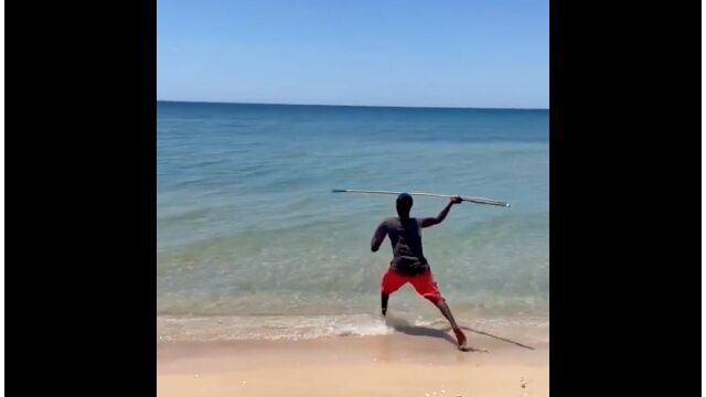 波打ち際で銛を投げ、魚を捕るアボリジニ