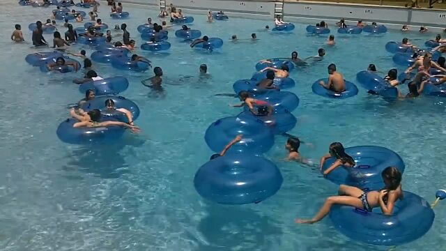 波のプールで溺れる少女を、ライフガードが颯爽と救う瞬間