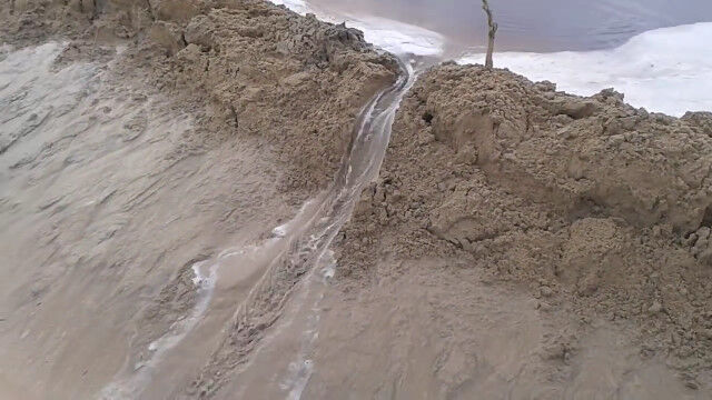 ダムの決壊が徐々に広がる、大きな砂のダムを崩してみた映像