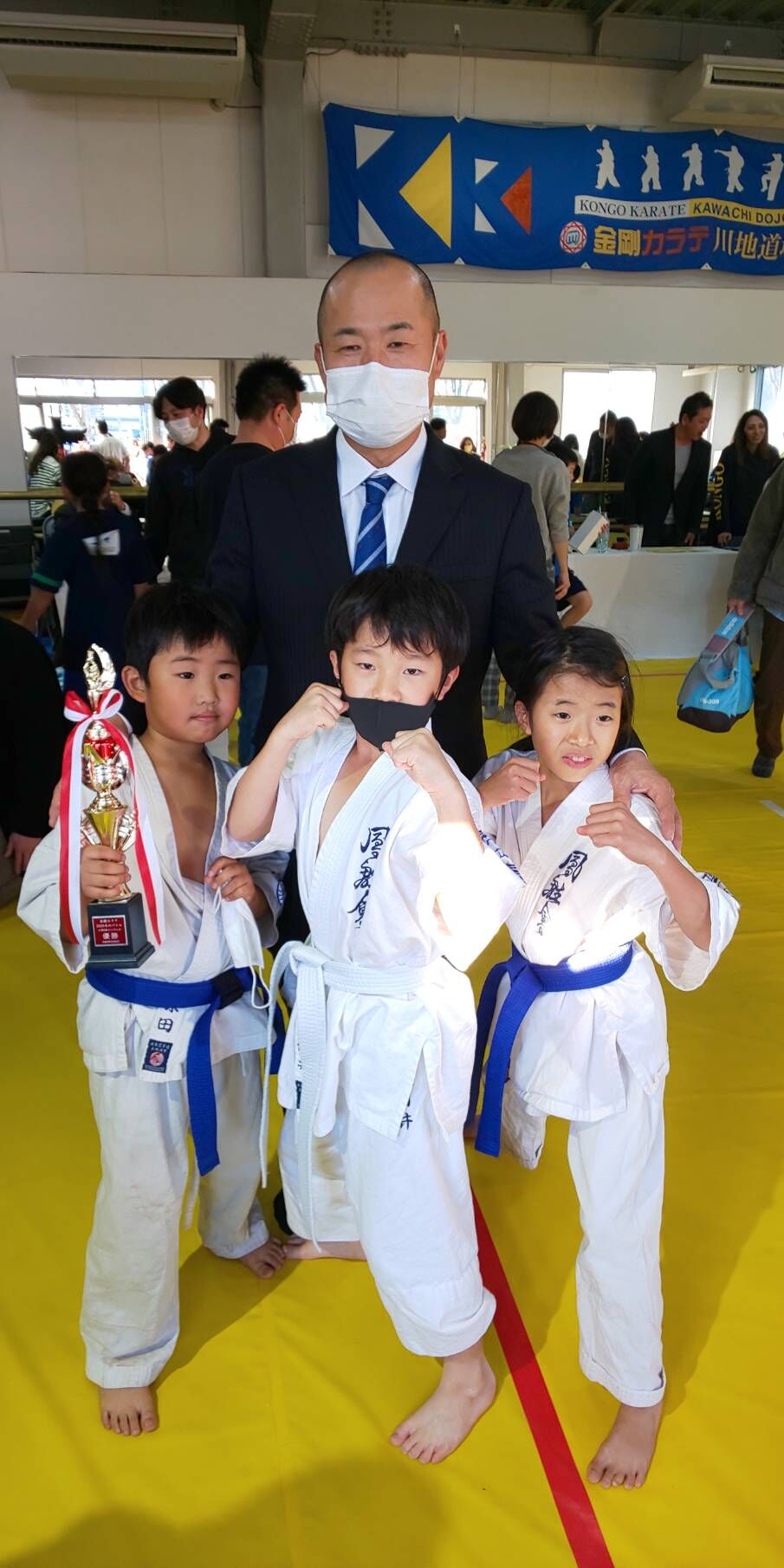 Japanese karate tournament event graphic with competitors, dojo branding, and event title in Japanese