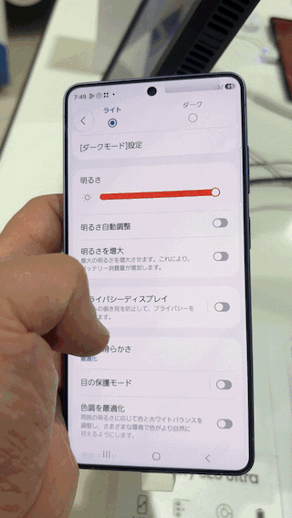 Galaxy S26 Ultra を正面から傾けた状態に持ち、プライバシーディスプレイ機能をオンにした GIF アニメ。画面がほとんど真っ黒になる。