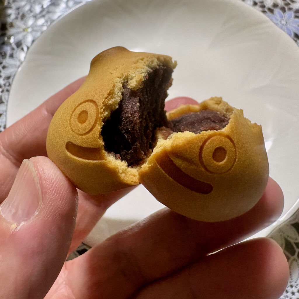 お皿の上でスライムまんじゅうを割って中身を見せてる、中身はあんこ
