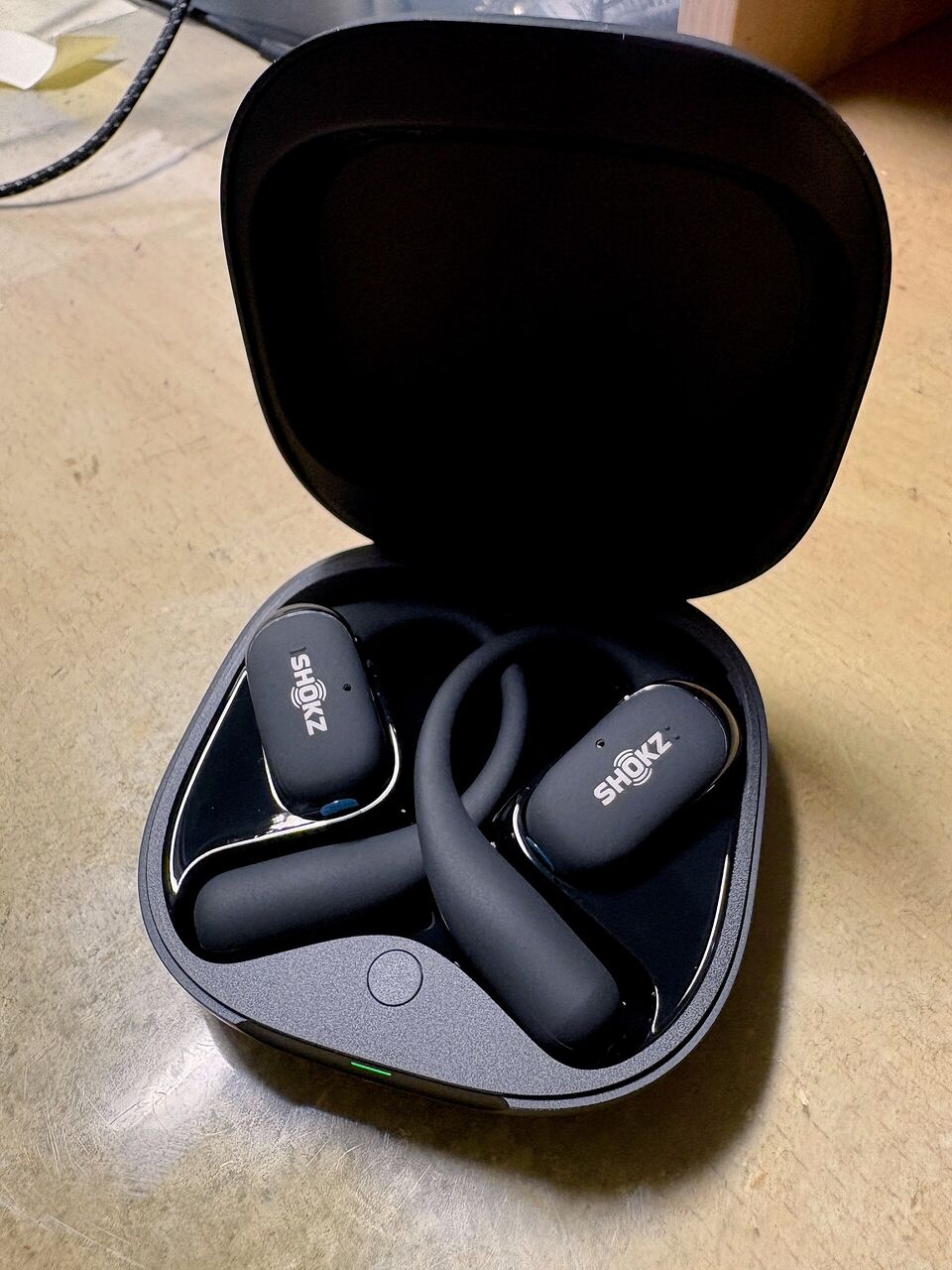 耳かけ型イヤホン OpenFit 2がケースに入った状態、ケースのフタが開いてて、中にイヤホン本体が左右両方とも入ってる