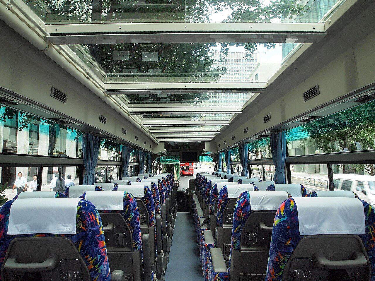 バスの車内写真、天井部分の大部分が透明なガラスになってて空が見えてる