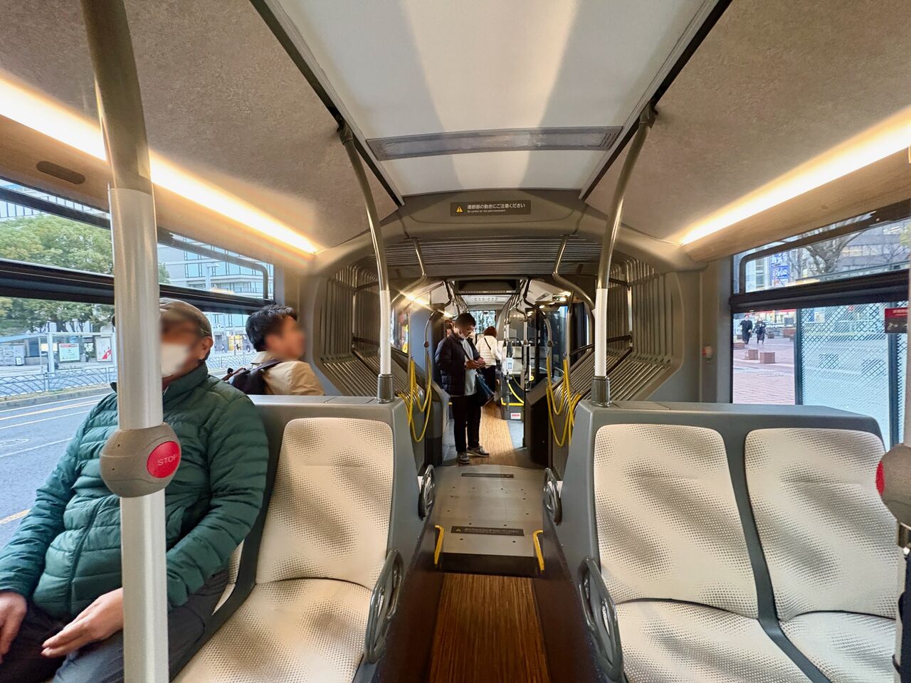 後ろ側車両の奥から連結部分を撮影した写真、写真手前には後ろ向きに向けられてる座席。連結部分は薄い灰色で溝が並ぶ。