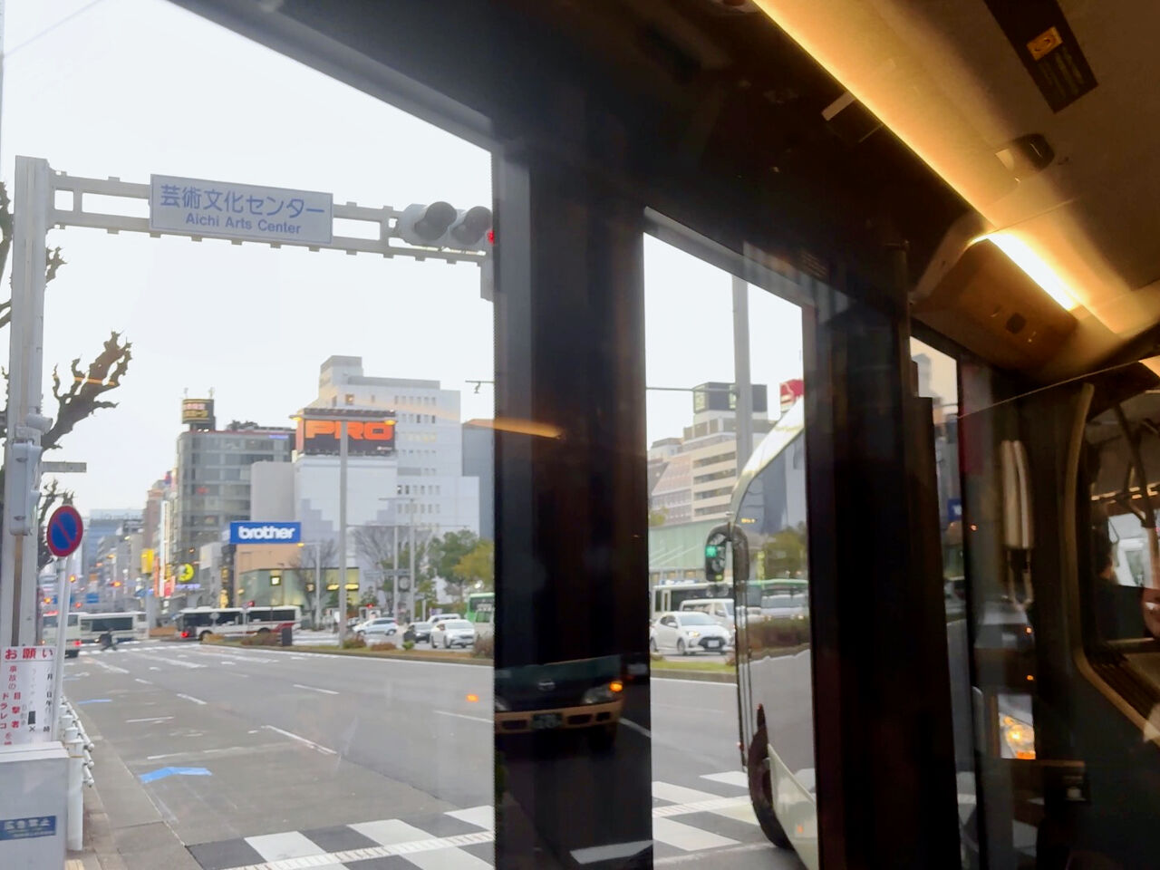 SR車内から名古屋栄の中心市街地を見てる、動画からクリップしたものなので画質が少し荒い、少し離れた所にビル街、後ろの方の席からカーブで撮影したので、前の方の車体が見えてる
