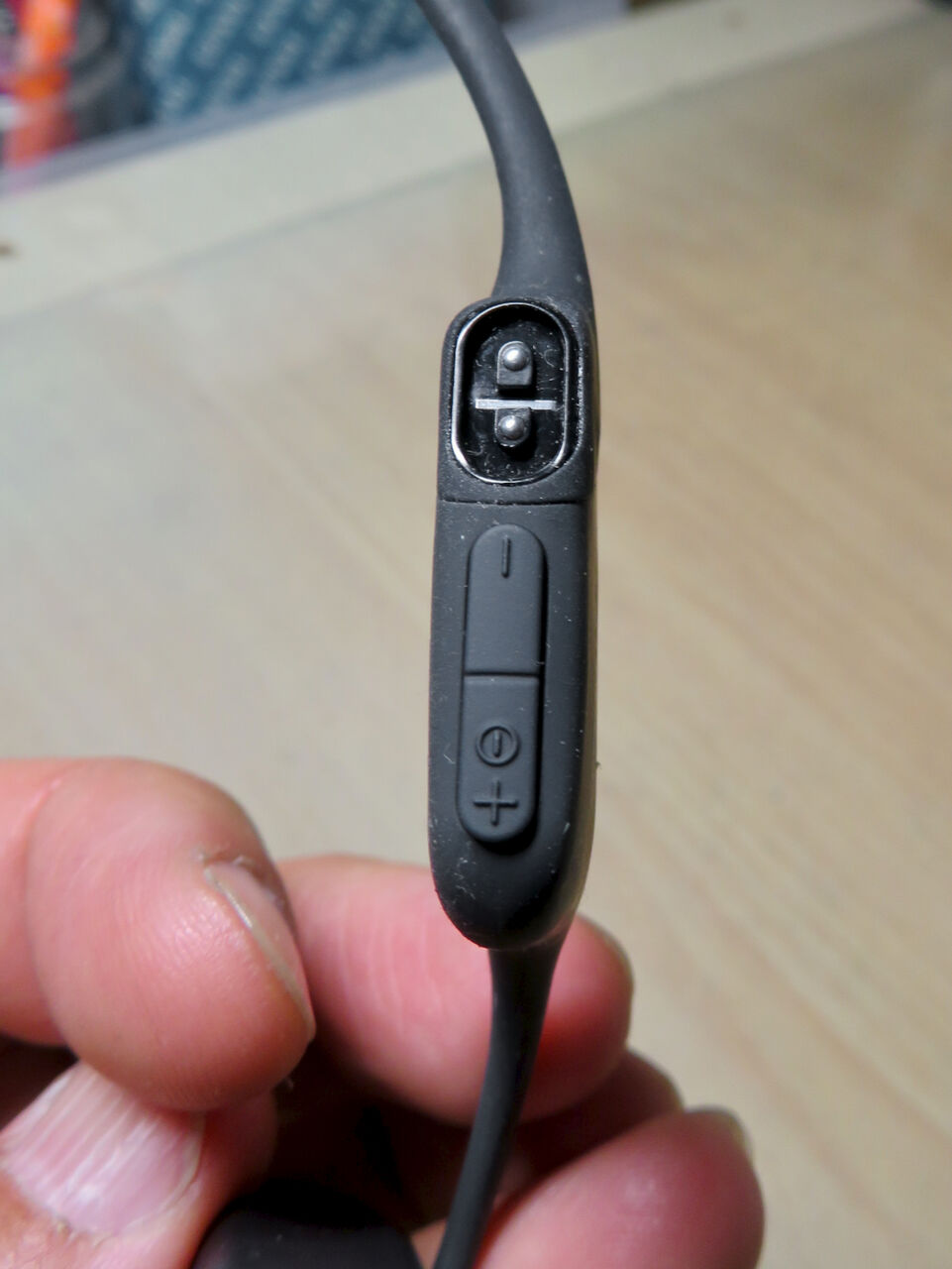 骨伝導ワイヤレスヘッドホン「AfterShokz Aeropex」 - 23:電源兼音量調整ボタンと充電コネクタ